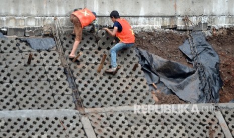  Pekerja menyelesaikan proyek normalisasi Sungai Ciliwung di Bukit Duri, Jakarta. 