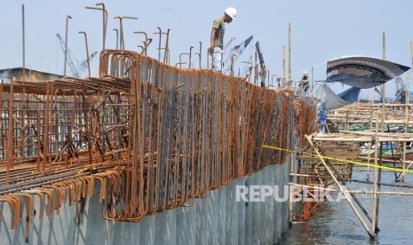 Pekerja menyelesaikan proyek pembangunan tanggul laut. (ilustrasi)