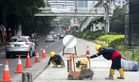 Pekerja menyelesaikan proyek perbaikan dan pemeliharaan jalan lajur TransJakarta Koridor I di Jalan Jenderal Sudirman, Jakarta, Rabu (16/3).