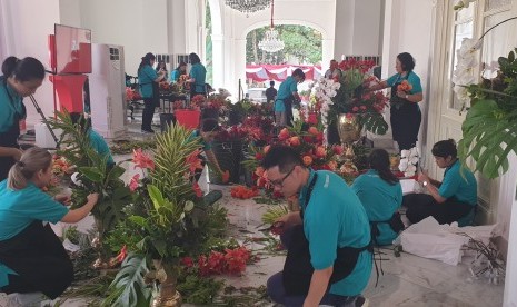 Pekerja menyiapkan rangkaian bunga untuk dekorasi 17 Agustus di Istana Negara, Jumat (16/8). 