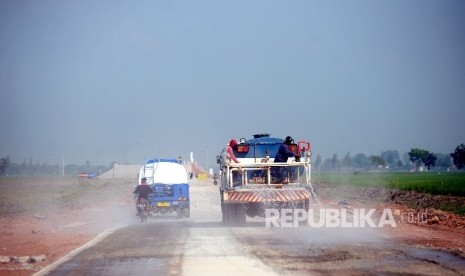  Pekerja menyirami jalan untuk mengilangkan debu ruas jalan tol Brebes-Gringsing, Jateng, Rabu (14/6). 