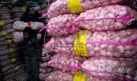  Pekerja menyusun bawang putih impor saat bongkar muat di Pasar Induk Kramat Jati,Jakarta,Senin (10/12).    (Republika/Prayogi)