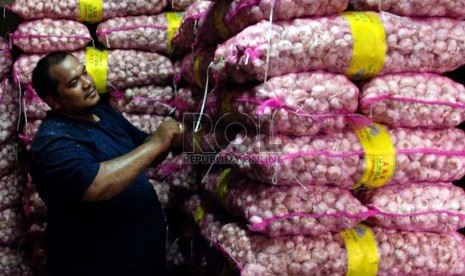 Pekerja menyusun Bawang Putih impor saat bongkar muat di Pasar Induk Kramat Jati, Jakarta, Senin (10/12).