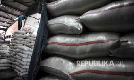  Pekerja menyusun karung beras di Pasar Induk Cipinang, Jakarta, Senin (2/1). 