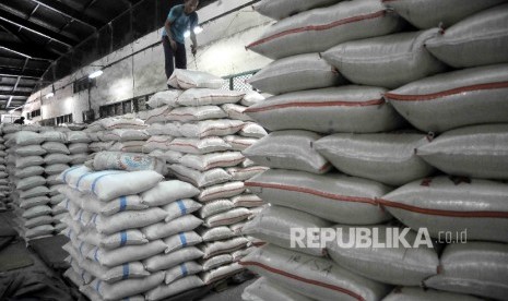 Pekerja menyusun karung beras di Pasar Induk Cipinang, Jakarta, Senin (2/1). 