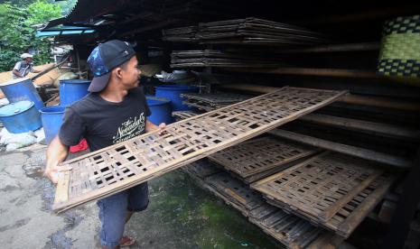 Pekerja merapihkan alat-alat untuk membuat tempe di Pabrik tempe rumahan di Cipulir, Kebayoran Lama, Jakarta, Senin (21/2/2022). Perajin dan pedagang tahu tempe yang ada di Jabodetabek dan Jawa Barat melakukan mogok produksi dan dagang pada tanggal 21 hingga 23 februari 2022, hal itu dipicu karena tingginya harga kedelai yang mencapai Rp11.200 perkilogram.