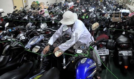   Pekerja merapihkan motor pemudik dalam KM Dobonsolo yang akan diberangkatkan ke Semarang dari Pelabuhan Tanjung Priok, Jakarta, Sabtu (3/8).  (Republika/Prayogi)