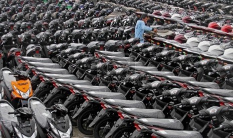 Pekerja merapihkan sepeda motor yang siap dikirim ke sejumlah daerah di pelabuhan Tanjung Priok, Jakarta, Kamis (21/3).