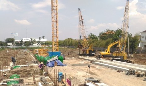 Pekerja merapikan besi-besi tiang pancang proyek Bintara Residence.