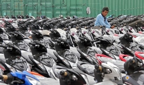 Pekerja merapikan sepeda motor yang siap dikirim ke sejumlah daerah di Pelabuhan Tanjung Priok, Jakarta.  