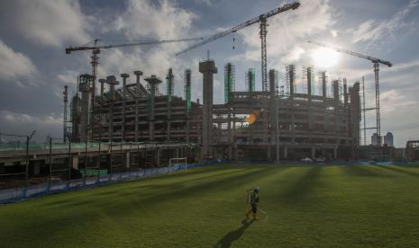 Pekerja merawat rumput lapangan latihan di lokasi pembangunan Jakarta International Stadium (JIS) di Papanggo, Tanjung Priok, Jakarta Utara, Selasa (9/3/2021). Saat ini kemajuan pembangunan stadion yang diproyeksikan berkapasitas 82.000 penonton itu mencapai 49,94 persen (data terakhir PT Jakarta Propertindo per 9 Maret 2021).