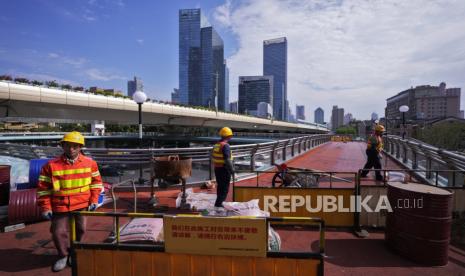 Pekerja merenovasi jembatan penyeberangan orang di Shanghai, Rabu, 9 Oktober 2024.