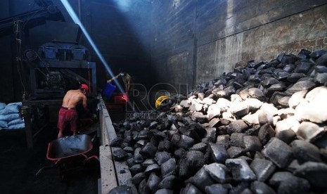  Pekerja mewadahi briket batubara yang sudah di cetak di  lingkungan balai pengembangan perindustrian sub unit pengembangan IKM logam, Gedebage, Kota Bandung, Kamis (6/8). (foto : Septianjar Muharam)