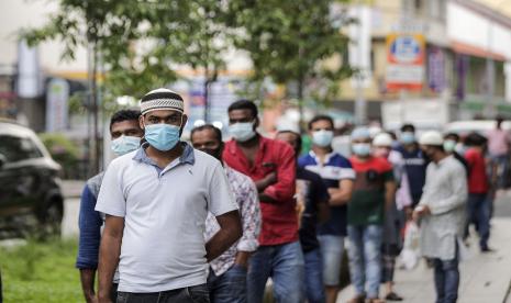 Pekerja migran di Singapura mengantre pembagian makanan di kawasan Little India. Pertama kalinya selama pandemi Singapura catat lebih dari 5.000 kasus Covid-19 sehari. Ilustrasi.