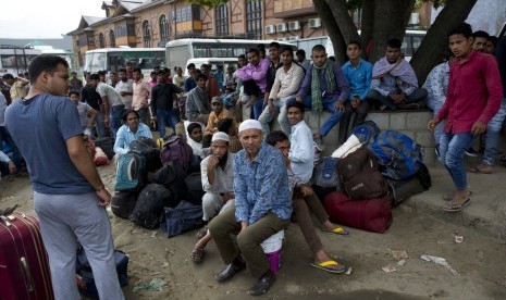 Pekerja migran India menunggu bus di Srinagar untuk keluar dari Kashmir, Selasa (6/8). Karena Kashmir diisolasi, ratusan pekerja ini kembali ke desanya di utara dan timur India.