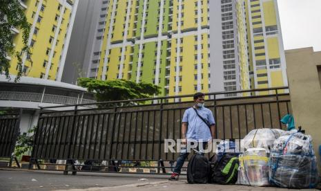 Pekerja Migran Indonesia (PMI) menunggu kendaraan usai menjalani karantina di kompleks Rumah Susun (Rusun) Pasar Rumput, Jakarta, Rabu (5/1/2022). Pemerintah mengurangi masa karantina bagi pelaku perjalanan luar negeri di Indonesia menjadi 7 sampai 10 hari dari sebelumnya 10 hingga 14 hari karena kasus COVID-19 di Indonesia sudah mulai menurun.