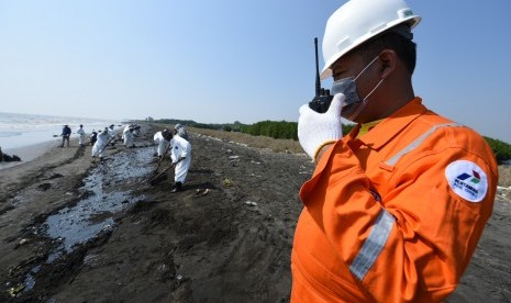 Pekerja Pertamina Hulu Energi Offshore North West Java (PHE ONWJ) memantau sekaligus mengawal warga yang membantu membersihkan ceceran tumpahan minyak di sepanjang Pantai Sedari, Karawang, Jawa Barat, Kamis (1/8/2019).