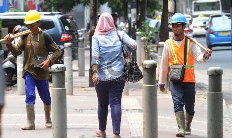  Pekerja sedang berjalan pada kawasan pusat bisnis di Jl Sudirman, Jakarta.