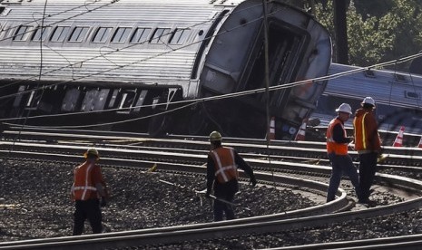 Pekerja sedang melakukan pengecekan terhadap peristiwa anjloknya kereta Amtrak di Philadelphia, Rabu (13/5).