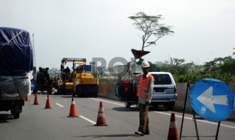 Pekerja sedang melakukan perbaikan di jalan Tol Tangerang-Merak, Banten, Kamis (28/5).