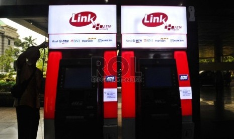  Pekerja sedang memasang unit baru ATM Himpunan Bank-Bank Milik Negara (Himbara) di perkantoran, Jakarta, Senin (7/12).