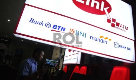  Pekerja sedang memasang unit baru ATM Himpunan Bank-Bank Milik Negara (Himbara) di perkantoran, Jakarta, Senin (7/12).