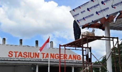 Pekerja sedang membangun atap loket parkir di kawasan Stasiun Tangerang, Banten, Selasa (28/4).