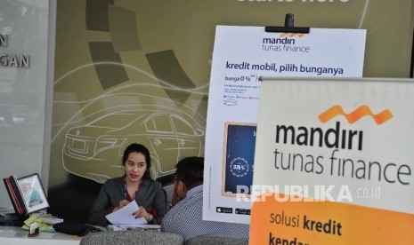 Pekerja sedang memberikan informasi kepada pengunjung di showroom mobil di Jakarta.