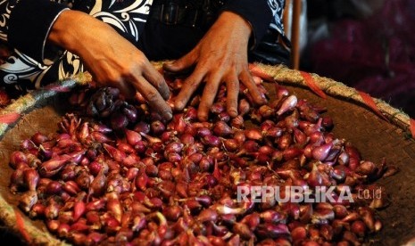 Pekerja sedang membersihkan bawang merah di pasar Induk, Jakarta, Selasa (19/4). (Republika/Tahta Aidilla)