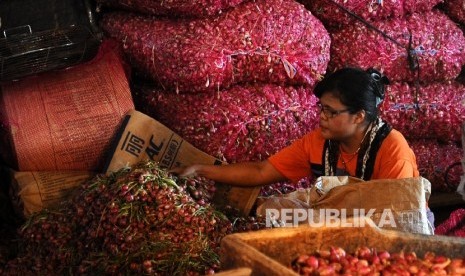 Pekerja sedang membersihkan bawang merah di pasar Induk, Jakarta. (Republika/Tahta Aidilla )