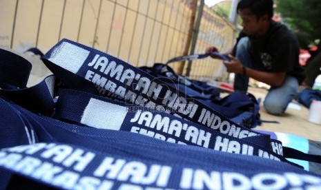  Pekerja sedang membuat tali tas paspor Jamaah Haji di Asrama Haji, Bekasi, Ahad (13/9).  (Republika/Tahta Aidilla)