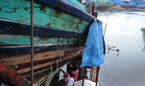 Pekerja sedang memperbaiki kapal kayu di Dok Muara Angke, Pluit, Jakarta Utara, Senin (26/1). (Republika/ Tahta Aidilla)