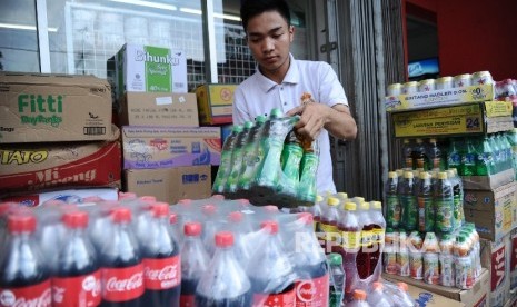 Pekerja sedang mengatur produk di minimarket, Jakarta, Jumat (22/4). (Republika/Tahta Aidilla)