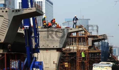 Pekerja sedang menyelesaikan proyek infrastruktur di kawasan Kuningan,Jakarta, Selasa (7/7).