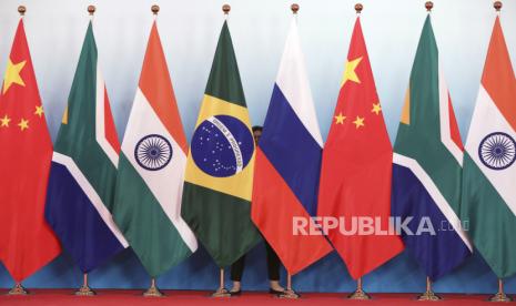 Pekerja staf berdiri di belakang bendera nasional Brasil, Rusia, China, Afrika Selatan, dan India untuk merapikan bendera menjelang foto bersama selama KTT BRICS di Pusat Konferensi dan Pameran Internasional Xiamen di Xiamen, Provinsi Fujian, Cina tenggara, Senin, 4 September 2017.