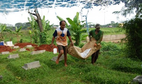 Pekerja tengah membongkar salah satu makam di Tempat Pemakaman Umum (TPU) Kampung Bayur, Cipingang Melayu, Jakarta Timur, Jumat (16/5).