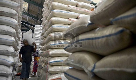 Pekerja Tengah Memikul Karung Beras di Pasar Induk Cipinang