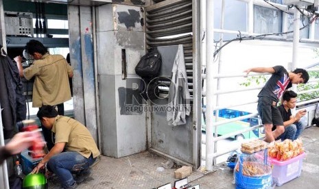   Pekerja tengah memperbaiki lift di halte Busway Sarinah, Jakarta Pusat, Senin (17/12).  (Rakhmawaty La'lang)