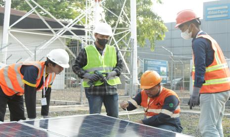 Pekerja Xurya membangun pembangkit listrik tenaga surya (PLTS).