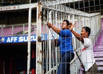 Pekerja memperbaiki pagar Stadion GBK, Senin (27/12)