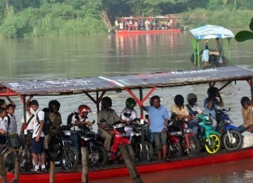 Pelajar dan warga menyeberang sungai dengan naik perahu. (ilustrasi)