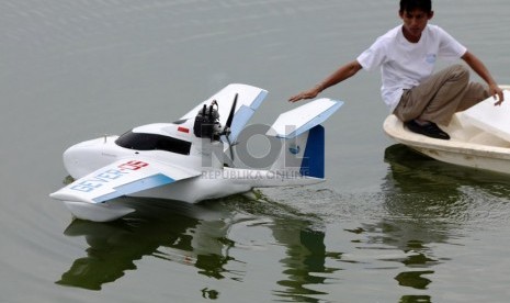 Pelajar dari Institut Maritim Indonesia (IMI) melakukan uji coba prototipe 'Perahu Terbang' (Flyingboat) di Situ Gintung, Ciputat, Tangerang Selatan, Banten, Rabu (18/12).   (Republika/Yasin Habibi)