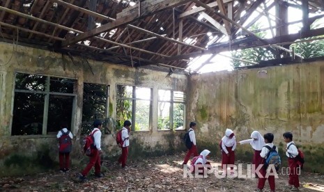 Pelajar Kelas 2 SDN Longkewang, Kecamatan Cicantayan Kabupaten Sukabumi tengah melihat ruangan kelas yang sudah sepuluh tahun rusak dan tidak bisa digunakan Rabu (9/8).