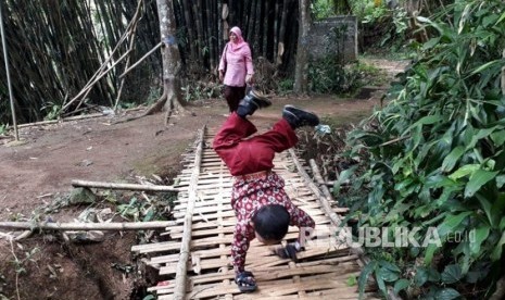 Pelajar Kelas III SDN 10 Cibadak Kabupaten Sukabumi, Mukhlis Abdul Kholik (8 tahaun) berjalan merangkak di sekolahnya, Kamis (8/11).