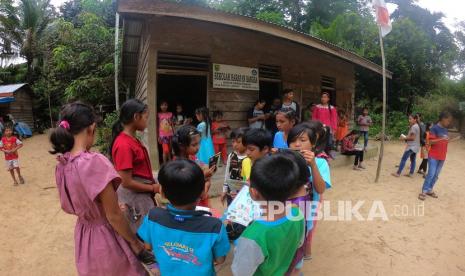 Pelajar Kelas Jauh SDN 004 Rantau Langsat membaca buku di luar kelas sebelum mengikuti kegiatan belajar mengajar di Dusun Bengayauan, Rantau Langsat, Batang Gangsal, Indragiri Hulu, Riau, Selasa (18/8/2020). Kelas jauh yang berada di dalam kawasan Taman Nasional Bukit Tigapuluh (TNBT) tersebut merupakan satu-satunya fasilitas pendidikan dengan satu ruangan yang bisa dimanfaatkan warga Suku Talang Mamak setempat.