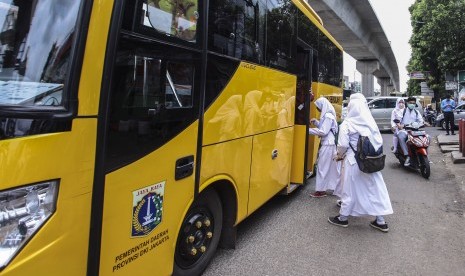 Pelajar menaiki armada bus sekolah gratis di Jakarta, Jumat (13/1).