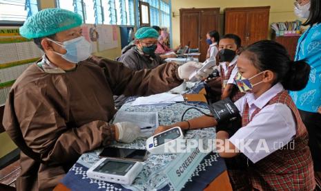 Pelajar menjalani pemeriksaan kesehatan awal saat vaksinasi Covid-19 bagi anak usia 6-11 tahun di SD Santa Maria Danupayan, Bulu, Temanggung, Jawa Tengah, Kamis (6/1/2022). Anak perlu diberi pengertian untuk menjaga kesehatan umum sebelum divaksinasi.