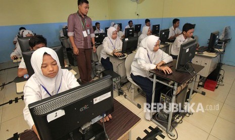 Pelajar menunggu bisa diaksesnya server Ujian Nasional Berbasis Komputer (UNBK), Senin (23/4).