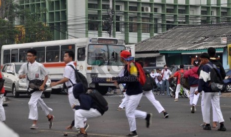  Pelajar saling melempar batu saat terlibat dalam tawuran pelajar di kawasan Matraman, Jakarta Timur, Senin (2/12).  (Republika/Rakhmawaty La'lang)