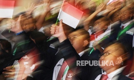 Pelajar SD mengibarkan bendera saat mengikuti literasi keuangan dan perbankan di Bursa Efek Inonesia (BEI), Jakarta, Jumat (9\9).